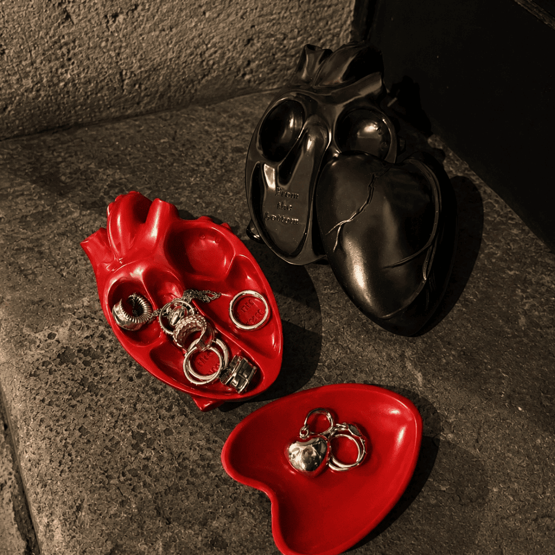 Red and black Gothic heart-shaped catchall trays holding rings and small jewelry