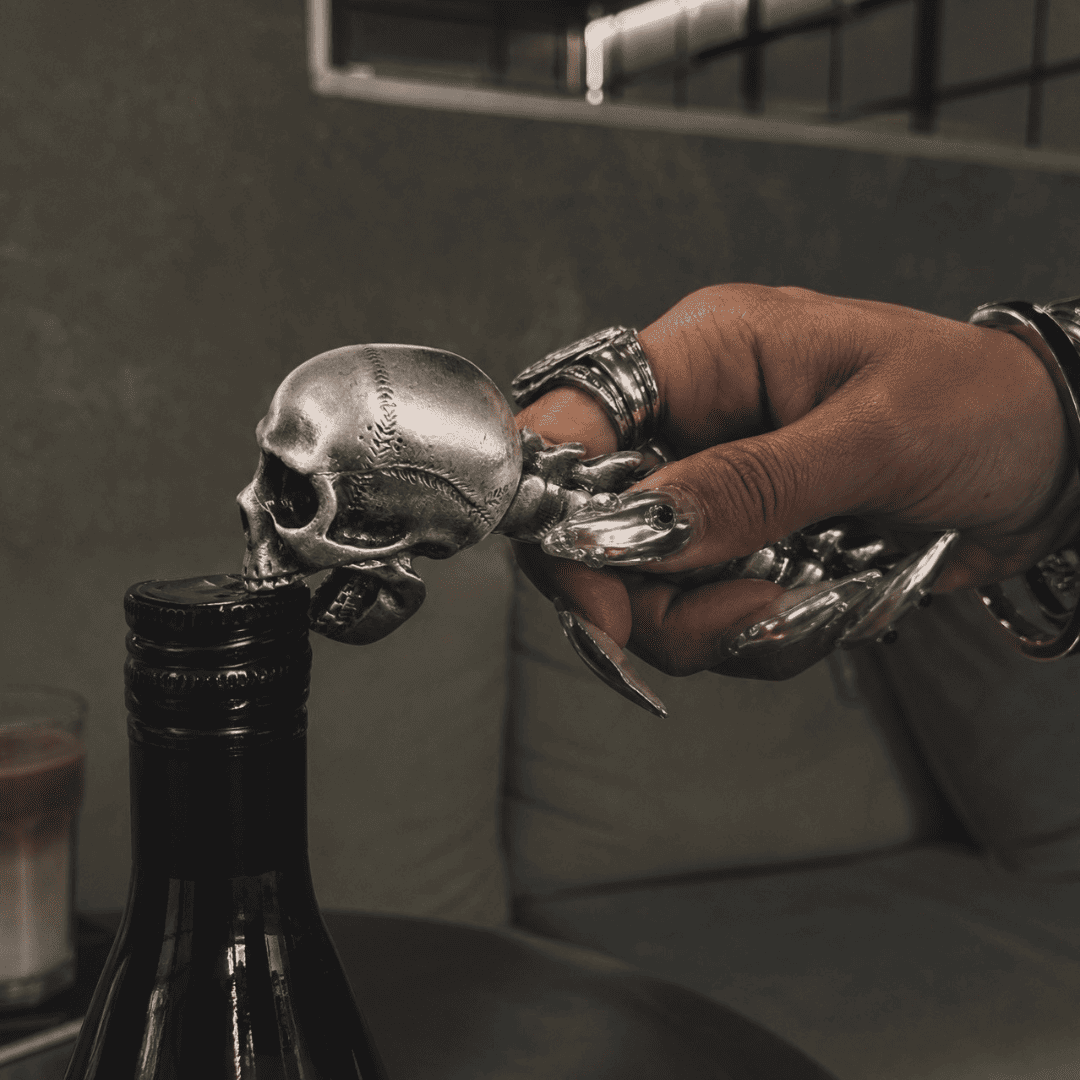 Gothic skull bottle opener being used to open a bottle